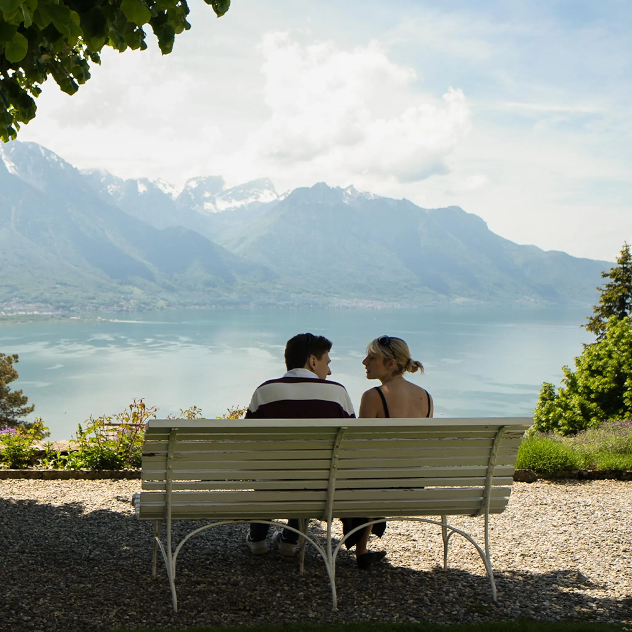 Luca et Lou assis sur un banc, le lac en arrière-plan.